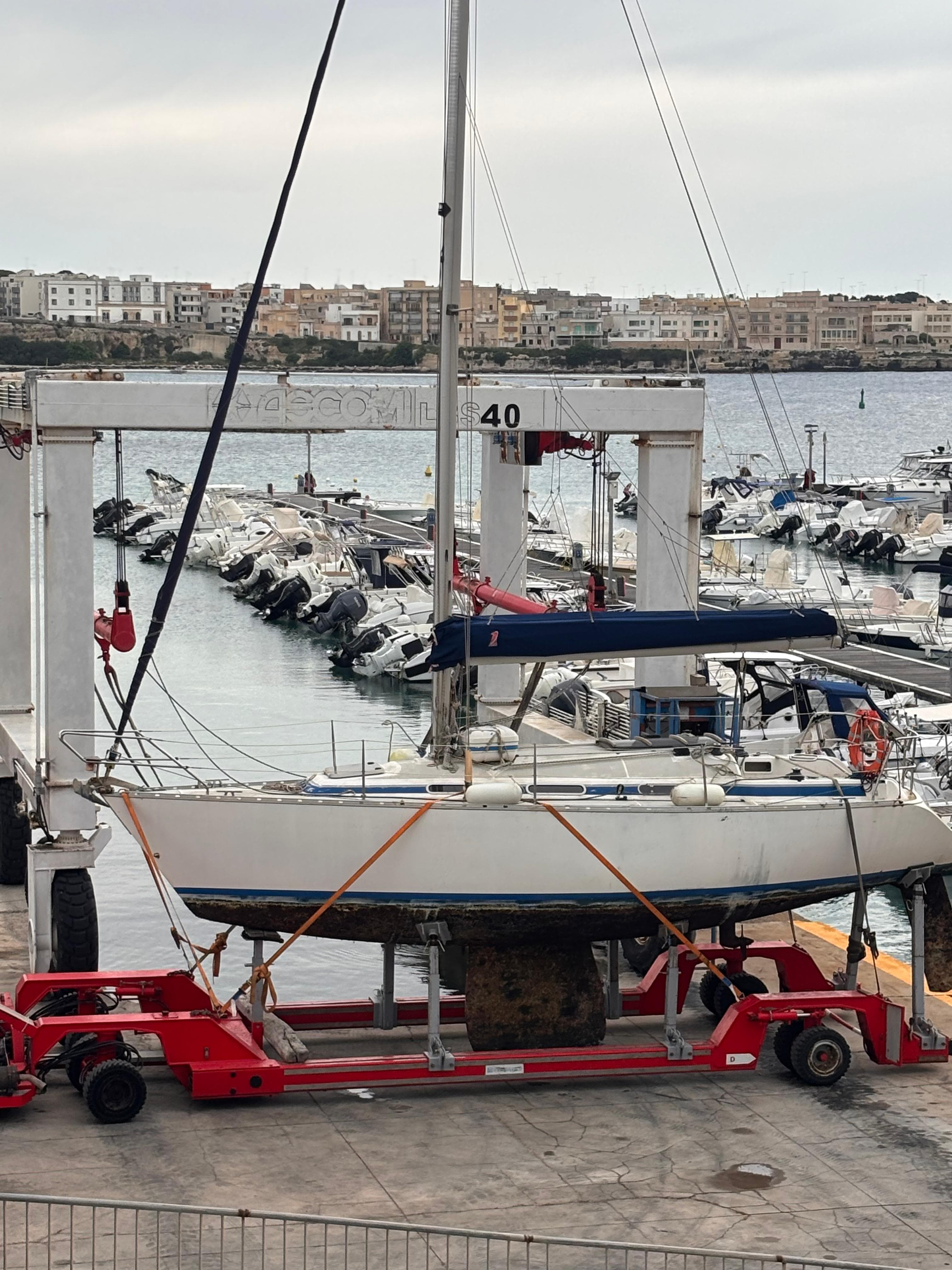 Trasporto imbarcazione su carrello e travel-lift nel porto di Otranto.
